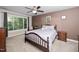 Cozy bedroom features a decorative dark-wood bed frame, natural light, and neutral-toned walls at 203 W Hill Dr, Cary, NC 27519
