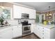 Bright kitchen features white cabinets, stainless steel appliances, granite countertops, and a view into the dining area at 203 W Hill Dr, Cary, NC 27519