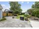 Spacious backyard featuring a stone patio, fire pit, mature trees, and a charming storage shed at 208 Maywood Ave, Raleigh, NC 27603