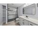 Modern bathroom featuring tiled floors, glass shower, and white vanity with black hardware at 208 Maywood Ave, Raleigh, NC 27603