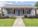 Charming blue home featuring a cozy front porch with lovely landscaping and inviting curb appeal at 208 Maywood Ave, Raleigh, NC 27603