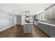 Modern kitchen with an island gas cooktop, stainless appliances, and grey cabinets at 208 Maywood Ave, Raleigh, NC 27603