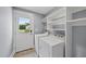 Bright laundry area features modern washer and dryer, shelving, and natural light from exterior door at 208 Maywood Ave, Raleigh, NC 27603