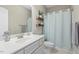 Cozy bathroom with a single sink, floating shelves, and a shower with a curtain at 21 Boots Dr, Angier, NC 27501