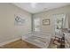 Well-lit bedroom with hardwood floors, rocking chair, and white wooden crib at 21 Boots Dr, Angier, NC 27501
