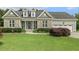 Charming home with stone and gray siding, dormer windows, manicured landscaping, and a welcoming front porch at 21 Boots Dr, Angier, NC 27501