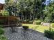 Backyard with a fire pit, chairs, a wood shed, and a beautiful view of the wooded property at 2125 Pine Dr, Raleigh, NC 27608