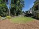 Expansive backyard featuring lush green grass, mature trees, and a glimpse of the home's exterior at 2125 Pine Dr, Raleigh, NC 27608