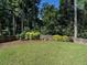 Backyard with well-maintained lawn, mature trees, and a privacy fence at 2125 Pine Dr, Raleigh, NC 27608