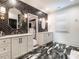 Bathroom with dual vanities, herringbone accent wall and black and white marble-patterned floor at 2125 Pine Dr, Raleigh, NC 27608