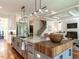 Open-concept kitchen with island, modern appliances, and view into the living room and staircase at 2125 Pine Dr, Raleigh, NC 27608