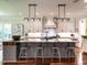 Gourmet kitchen featuring a large island with counter seating, stainless appliances, and custom lighting at 2125 Pine Dr, Raleigh, NC 27608