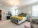 Bright main bedroom featuring a bed with decorative pillows, a side table, and an armchair at 2125 Pine Dr, Raleigh, NC 27608