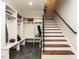 Mudroom with white built-in storage, dark tile flooring, and stairs to the upper level at 2125 Pine Dr, Raleigh, NC 27608