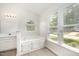 Bright bathroom featuring a soaking tub, vanity with sink, and large windows for natural light at 220 Needle Park Dr, Cary, NC 27513