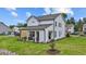 Landscaped backyard highlighting the rear of the home, a covered patio, and a wooden privacy fence at 223 Faith Avenue, Sanford, NC 27330