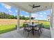Covered patio features a ceiling fan, stylish rug, and outdoor dining set overlooking the backyard at 223 Faith Avenue, Sanford, NC 27330