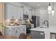 Modern kitchen with gray cabinets, stainless steel appliances, quartz countertops, and decorative lighting at 223 Faith Avenue, Sanford, NC 27330