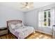 Bright bedroom features wood floors, ceiling fan, side table, and patterned bedding set at 229 White Oak Farm Dr, Willow Springs, NC 27592