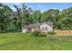 Charming single-story home with a well-maintained lawn, flower garden, and partial wooden fence under a blue sky at 229 White Oak Farm Dr, Willow Springs, NC 27592
