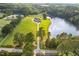 Aerial view of a charming waterfront home with a long driveway through mature trees at 2493 Nc-242, Benson, NC 27504