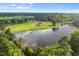 Panoramic aerial showcasing a beautiful pond-side home surrounded by verdant trees at 2493 Nc-242, Benson, NC 27504