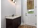Bathroom showcasing dark wood vanity with granite countertop, and a door leading to an outdoor space at 2493 Nc-242, Benson, NC 27504