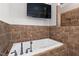 Luxurious bathroom featuring a soaking tub with tiled surround and wall-mounted TV at 2493 Nc-242, Benson, NC 27504