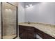 Bathroom with a stone vanity, walk-in shower with glass doors and tiled walls at 2493 Nc-242, Benson, NC 27504