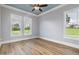 Light-filled bedroom with hardwood floors, ceiling fan, and two large windows at 2493 Nc-242, Benson, NC 27504