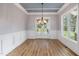 Dining area with white wainscoting, wood floors, and double doors leading to the outdoor living space at 2493 Nc-242, Benson, NC 27504
