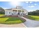 Inviting front porch with stone accents, white columns, and a lake view at 2493 Nc-242, Benson, NC 27504
