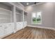 Bright living room featuring wood floors, white built-in shelves and cabinetry, and a large window with peaceful outdoor views at 2493 Nc-242, Benson, NC 27504