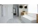 Bathroom view including soaking tub, wood cabinets, and view into primary bedroom at 25 Ruth Cir, Fuquay Varina, NC 27526