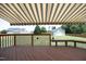 View of backyard from wooden deck with striped awning providing shade and built-in wooden bench seating at 25 Ruth Cir, Fuquay Varina, NC 27526