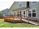 Back of house showing the deck with wooden railing, a ramp, awning, and access to the backyard at 25 Ruth Cir, Fuquay Varina, NC 27526