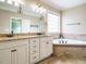 Luxurious bathroom showcasing granite countertops, double sinks, and a relaxing soaking tub by the window at 3021 Lawson Walk Way, Rolesville, NC 27571
