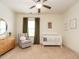 Bedroom with a rocking chair, white crib, side table and a ceiling fan at 3021 Lawson Walk Way, Rolesville, NC 27571