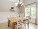 Bright dining room with wainscoting, a wooden table, and a modern chandelier at 3021 Lawson Walk Way, Rolesville, NC 27571