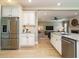 Modern kitchen with stainless steel appliances and an island overlooking the living area at 3021 Lawson Walk Way, Rolesville, NC 27571