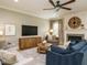 Relax in this cozy living room featuring a fireplace, ceiling fan, large TV, and comfortable seating at 3021 Lawson Walk Way, Rolesville, NC 27571