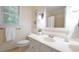 Bathroom featuring a white vanity, framed artwork, ample light and neutral color palette at 304 Ramblewood Dr, Raleigh, NC 27609