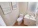 Half bath with a white vanity, toilet and framed art at 304 Ramblewood Dr, Raleigh, NC 27609