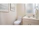 Half bath with a white vanity, toilet and framed art at 304 Ramblewood Dr, Raleigh, NC 27609