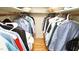 Organized walk-in closet with hanging clothes on both sides and wood flooring at 304 Ramblewood Dr, Raleigh, NC 27609
