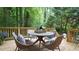 Outdoor deck area featuring a cozy seating arrangement and serene wooded surroundings at 304 Ramblewood Dr, Raleigh, NC 27609