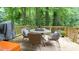Spacious deck with outdoor seating, grill, and a serene view of the surrounding trees at 304 Ramblewood Dr, Raleigh, NC 27609