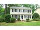 Traditional two-story home featuring black shutters and a welcoming front yard with brick walkway at 304 Ramblewood Dr, Raleigh, NC 27609