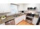 Bright kitchen features granite counters, white cabinets, and stainless steel appliances at 304 Ramblewood Dr, Raleigh, NC 27609