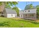 Backyard with lush green lawn featuring the house and a detached garage at 3129 Merrianne Dr, Raleigh, NC 27607